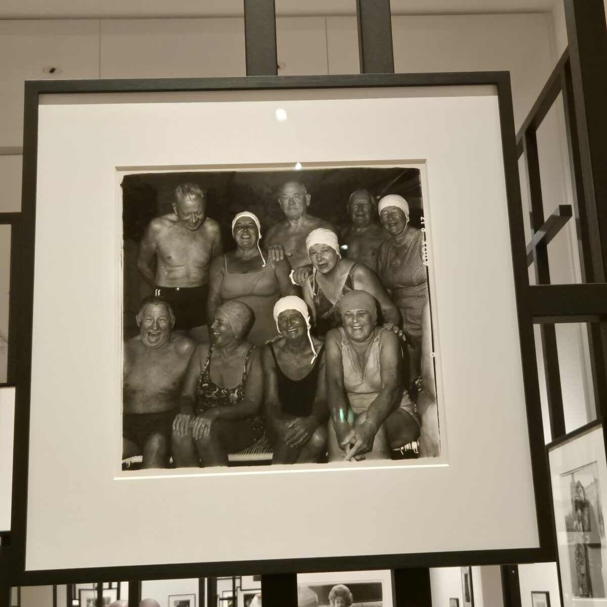 foto von diane arbus, von der ausstellung im gropius-bau berlin, es zeigt eine gruppe von lachenden menschen in badehauben