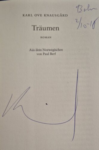 Erste Seite im Roman "Träumen" von Knåusgard, der Autor hat eine unleserliche Signatur hineingeschrieben und und oben rechts noch ein Datum, "Berlin 2/10-18"